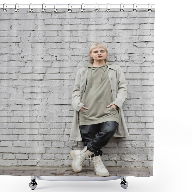 Personality  Young Woman With Makeup, Blonde Hair, Bangs, In Stylish Outfit, Long Hoodie, Coat, Black Leather Pants And Beige Boots Standing With Hands In Pockets Near Grey Brick Wall And Looking At Camera  Shower Curtains