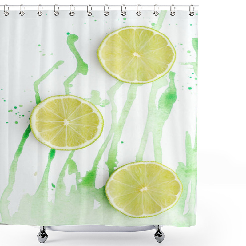 Personality  elevated view of three pieces of ripe limes on white surface with green watercolor shower curtains
