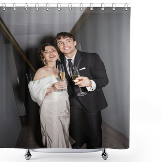 Personality  Joyful Groom Hugging Young And Brunette Bride In White Wedding Dress And Holding Glasses Of Champagne While Standing And Smiling Together In Hallway Of Hotel  Shower Curtains