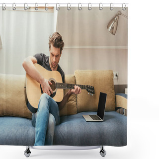 Personality  Focused Young Man Playing Guitar While Sitting On Sofa Near Laptop With Blank Screen Shower Curtains