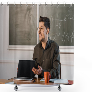 Personality  Smiling Male Teacher Sitting At Desk And Showing Laptop With Blank Screen In Classroom Shower Curtains