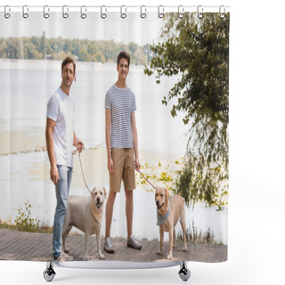 Personality  Father And Teenager Son Holding Leashes And Standing With Golden Retrievers Near Lake  Shower Curtains