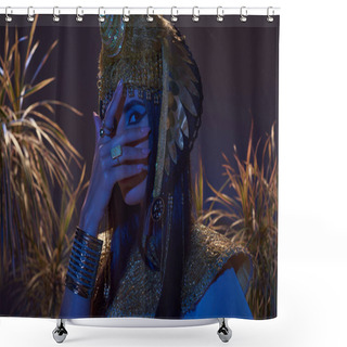 Personality  Woman In Egyptian Look Covering Face While Posing Near Plants In Blue Light On Brown Background Shower Curtains
