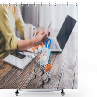 Personality  Selective Focus Of Small Shopping Bag In Shopping Trolley With Woman Using Laptop On Background Shower Curtains