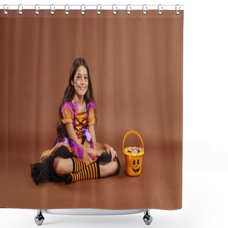 Personality  Cheerful Girl In Colorful Halloween Costume Sitting Near Bucket With Candies On Brown Backdrop Shower Curtains