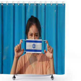 Personality  A Woman With Israel Flag On Hygienic Mask In Her Hand And Lifted Up The Front Face On Blue Background. Tiny Particle Or Virus Corona Or Covid 19 Protection. Concept Of Combating Illness. Shower Curtains