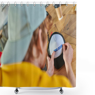 Personality  Blurred Young Designer Holding Printing Layer Near Snapback While Working Near Blurred Coffee To Go On Table In Print Studio, Hands-on Entrepreneurship Concept  Shower Curtains