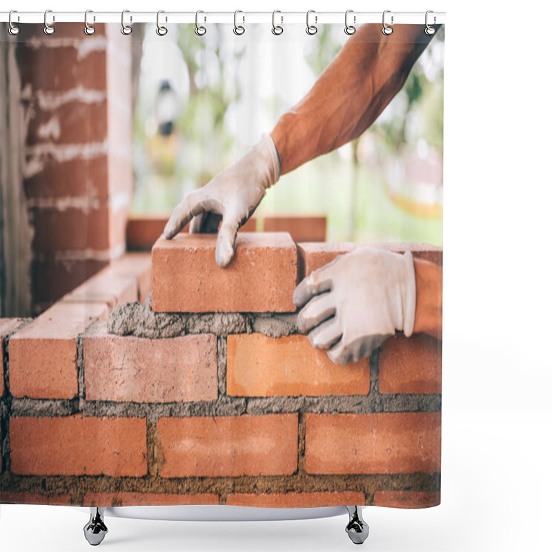 Personality  professional construction worker laying bricks and building barbecue in industrial site. Detail of hand adjusting bricks shower curtains