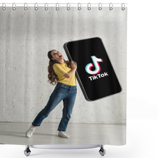 Personality  KYIV, UKRAINE - FEBRUARY 21, 2020: Attractive Woman Laughing While Holding Huge Model Of Smartphone With TikTok App Near White Brick Wall Shower Curtains