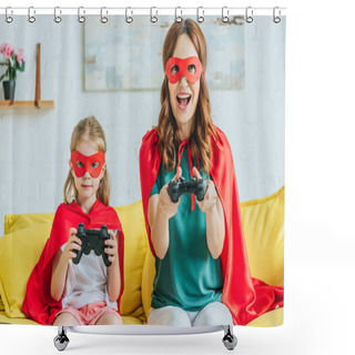 Personality  KYIV, UKRAINE - JULY 5, 2019: Cheerful Mother And Daughter In Costumes Of Superheroes Playing Video Game While Sitting On Sofa At Home Shower Curtains