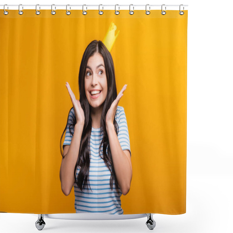 Personality  brunette woman in paper crown smiling and looking away isolated on yellow shower curtains