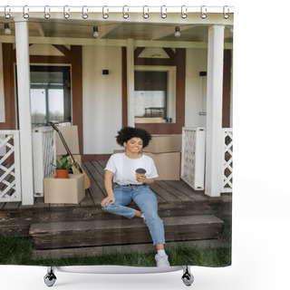 Personality  Cheerful African American Woman With Coffee To Go Sitting On Porch Near Boxes And New House Shower Curtains