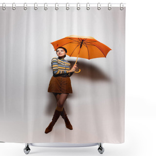 Personality  Full Length Of Smiling Young Woman In Striped Turtleneck And Skirt Posing With Orange Umbrella On Grey Shower Curtains