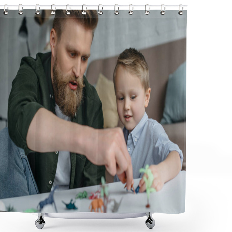 Personality  father and cute little son playing with various toy dinosaurs together at home shower curtains