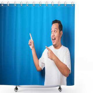 Personality  Portrait Of Funny Young Asian Man In White Tshirt Smiling And Pointing To Presenting Something On His Side, Against Blue Background With Copy Space Shower Curtains