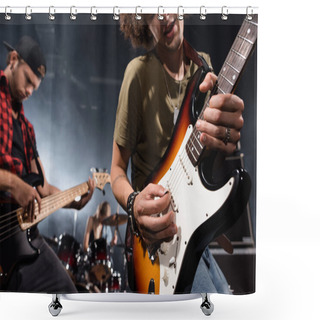 Personality  KYIV, UKRAINE - AUGUST 25, 2020: Curly Musician Playing Electric Guitar With Guitar Pick With Blurred Musicians On Background Shower Curtains