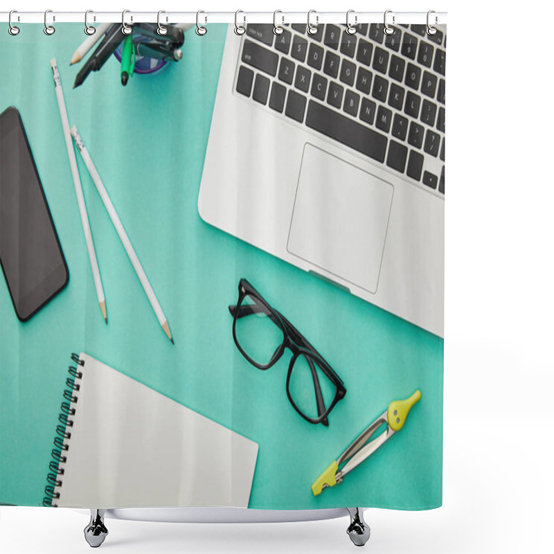 Personality  top view of gadgets near glasses, stationery and notebook isolated on turquoise shower curtains