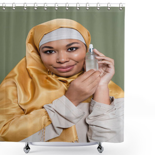 Personality  Portrait Of Multiracial Woman In Hijab Holding Cosmetic Serum Isolated On Green  Shower Curtains