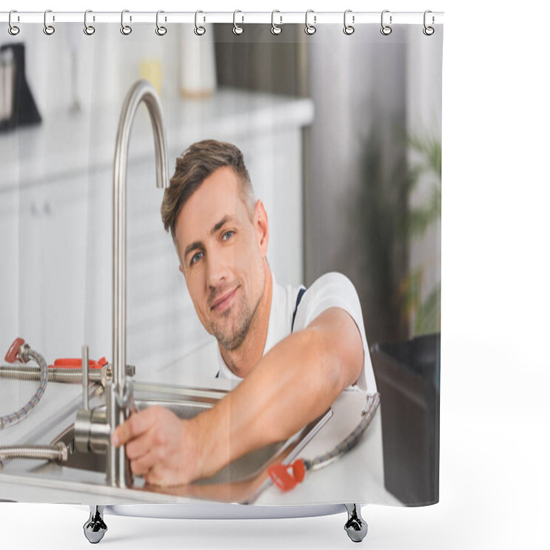 Personality  smiling adult repairman with spanner repairing faucet at kitchen and looking at camera shower curtains