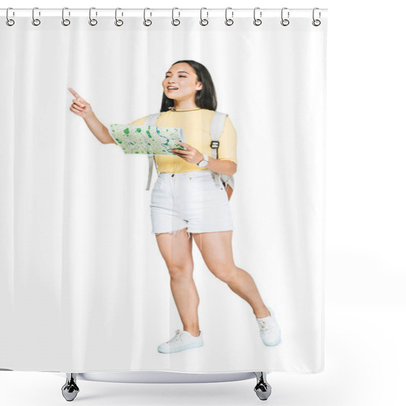 Personality  attractive asian girl looking away and pointing with finger while holding map on white background shower curtains