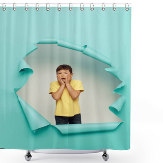 Personality  Shocked Multiracial Boy In Yellow T-shirt Touching Cheeks And Looking At Camera During World Child Protection Day While Standing Behind Hole In Blue Paper Background Shower Curtains