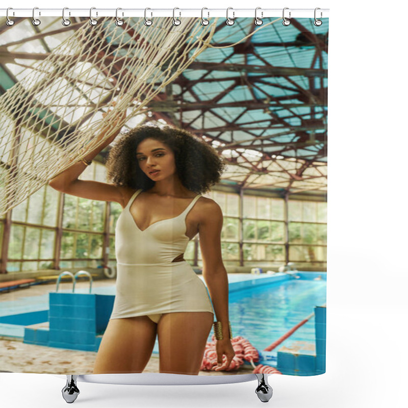 Personality  alluring african american woman in bathing suit standing near net by swimming pool with blue water shower curtains