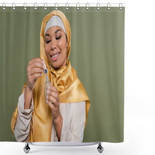 Personality  Positive Multiracial Woman In Hijab Holding Cosmetic Serum And Dropper Isolated On Green  Shower Curtains
