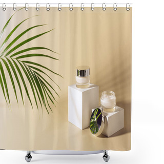 Personality  Close Up View Of Green Palm Leaf, Facial And Body Creams In Glass Jars On White Cubes On Beige Background Shower Curtains