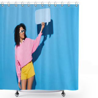 Personality  Pleased African American Woman In Pink Sweatshirt And Yellow Shorts Showing Empty Speech Bubble On Blue Shower Curtains