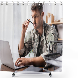 Personality  Pensive Soldier In Uniform Holding Pen And Using Laptop Near Document Tray On Blurred Foreground Shower Curtains