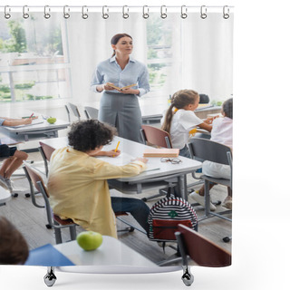 Personality  Selective Focus Of Teacher Holding Book While Standing In Classroom Near Multicultural Pupils Shower Curtains