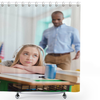 Personality  High School Teenage Female Student Listening To Music In Headphones During Lesson And African American Teacher Standing Behind Shower Curtains