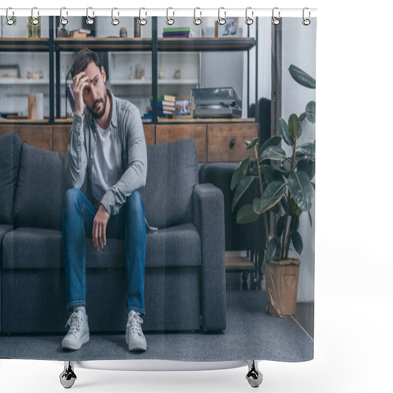 Personality  depressed man sitting on couch, touching face and grieving at home shower curtains