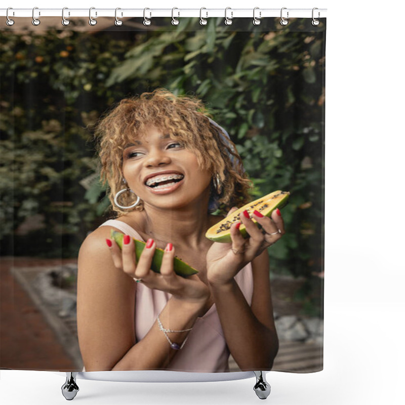 Personality  Positive young african american woman with braces in summer dress holding fresh papaya and looking away while standing near blurred plants in orangery, inspired by tropical plants, summer concept shower curtains