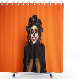 Personality  Smiling Woman In Sugar Skull Makeup And Black Halloween Costume Holding Hands Near Face Isolated On Orange Shower Curtains