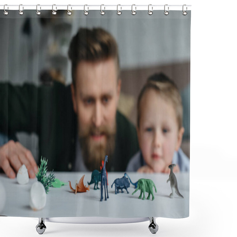 Personality  selective focus of father and cute little son looking at arranged toy dinosaurs on tabletop together at home shower curtains