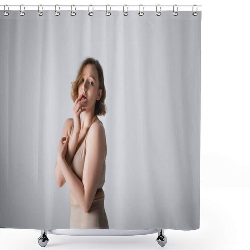 Personality  overweight young woman in underwear posing on grey shower curtains