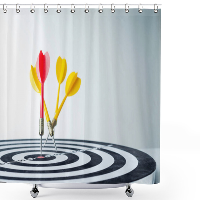 Personality  Close up shot red dart arrow on center of dartboard and yellow a shower curtains