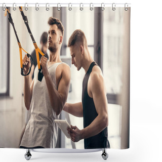 Personality  Trainer Using Digital Tablet And Helping Muscular Sportsman Exercising With Fitness Straps In Gym Shower Curtains