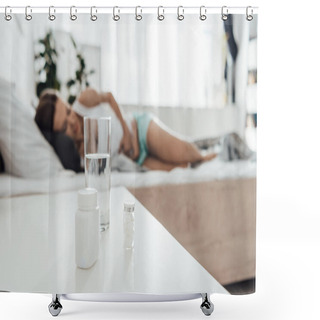 Personality  Selective Focus Of Suffering Woman In Bed And Pills With Glass Of Water On Foreground Shower Curtains
