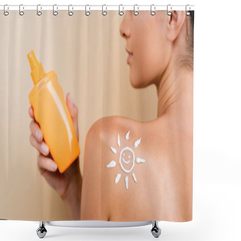 Personality  partial view of woman with image of happy sun on shoulder holding bottle of sunblock isolated on beige shower curtains