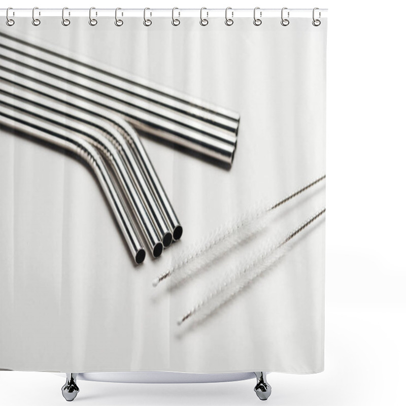 Personality  close up view of of stainless steel straws and cleaning brushes on grey shower curtains
