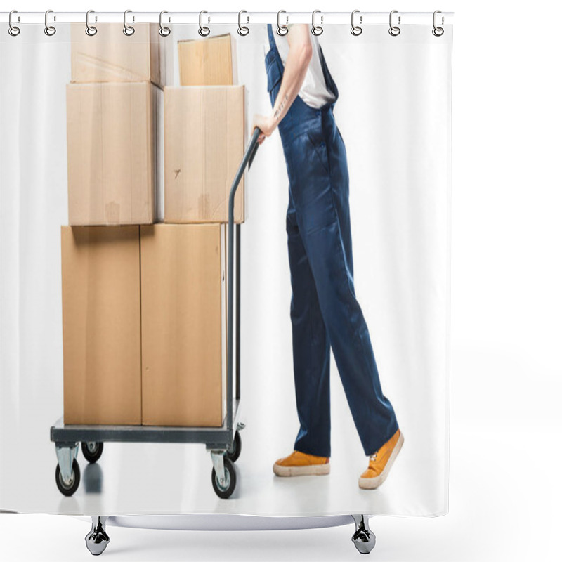 Personality  cropped view of mover in uniform transporting cardboard boxes on hand truck on white shower curtains