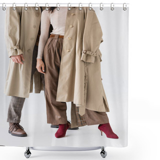 Personality  Cropped View Of Fashionable Couple In Trench Coats And Trousers Posing On Grey Shower Curtains