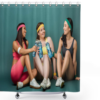 Personality  Multiethnic Sportswomen Sitting With Crossed Legs, Smiling, Holding Sports Bottles And Looking At Each Other On Green Shower Curtains