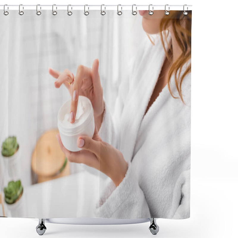 Personality  Cropped view of woman holding cosmetic cream in bathroom  shower curtains