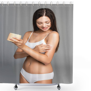 Personality  Smiling Young Adult Woman In White Underwear Applying Cream On Shoulder And Holding Jar On Grey Shower Curtains