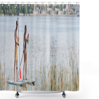 Personality  Full Length Of Active Multiethnic Couple In Colorful Swimwear Holding Paddles While Sailing On Sup Boards Along River With Green Bank In Summer, Banner Shower Curtains