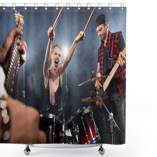 Personality  KYIV, UKRAINE - AUGUST 25, 2020: Blonde Woman With Outstretched Hands Screaming While Sitting At Drum Kit Near Guitarist With Backlit On Blurred Foreground Shower Curtains