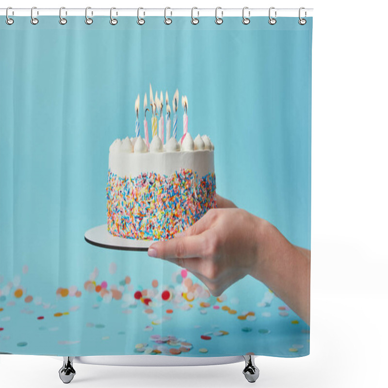 Personality  Partial view of woman holding birthday cake with candles on blue background with confetti shower curtains
